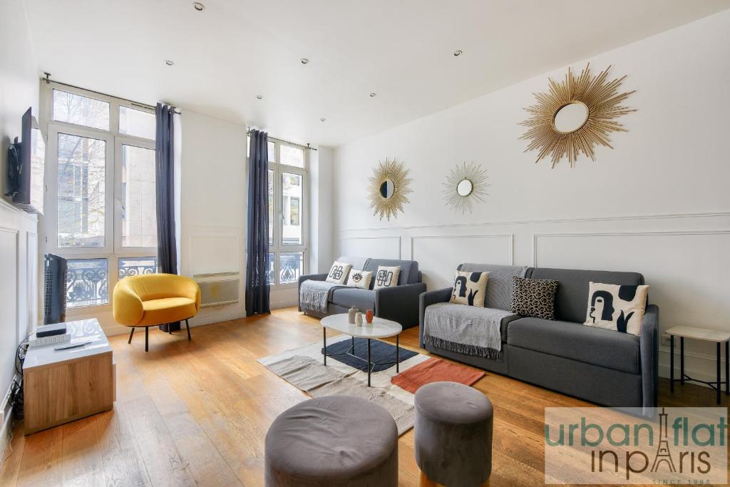 un salon avec un canapé et une table dans l'établissement Urban Flat 34 - Beautiful 3 Bedroom Paris Louvre, à Paris