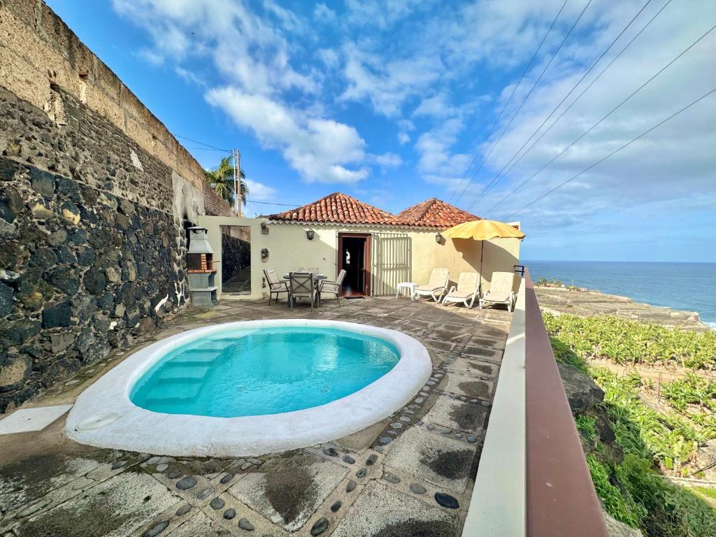 una piscina di fronte a una casa con l'oceano di Casa Dalia a La Orotava