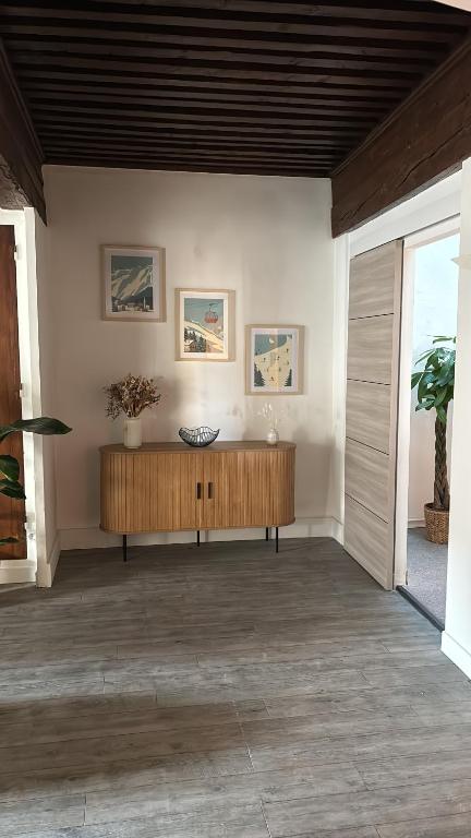 een woonkamer met een houten tafel en een houten plafond bij Le Clos Saint-Jacques in Grenoble