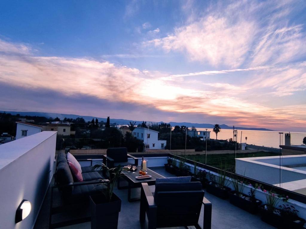 a balcony with a view of the ocean at sunset at New Luxury Georgia Beach Villa II in Argaka