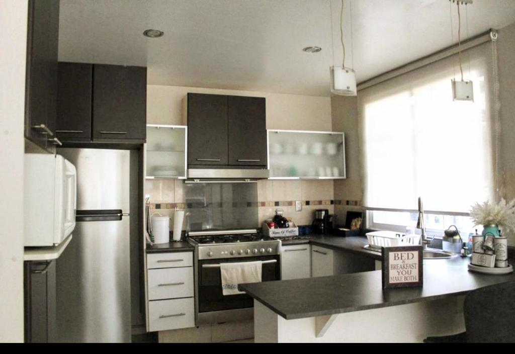 una cucina con frigorifero e fornello forno superiore di Acogedora Recamara Matrimonial con Blackout - A solo 2 cuadras del WTC! a Città del Messico