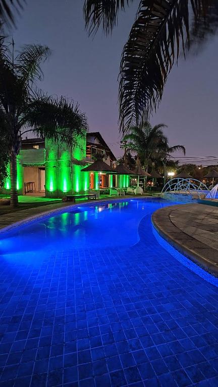 a swimming pool at night with green lights at Hotel El Cid in Villa Carlos Paz