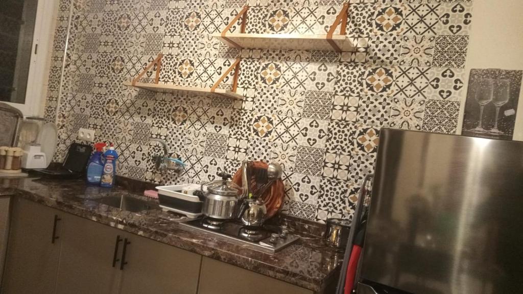 a kitchen with a stove and a refrigerator at Appartement Neuf Excellent Rapport Qualité Prix CHU TANGER Forêt Diplomatique IBN Batouta in Daidatz