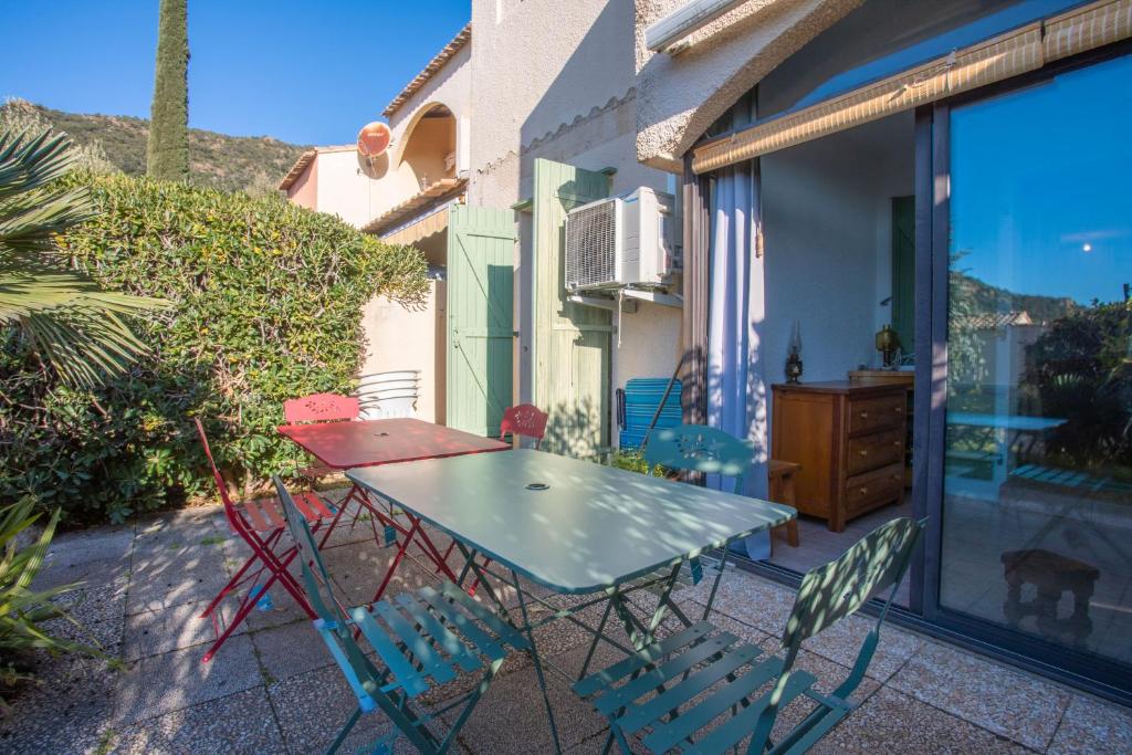 une table et des chaises assises sur une terrasse dans l'établissement Appartement Pramousiquer D23, à Rayol-Canadel-sur-Mer