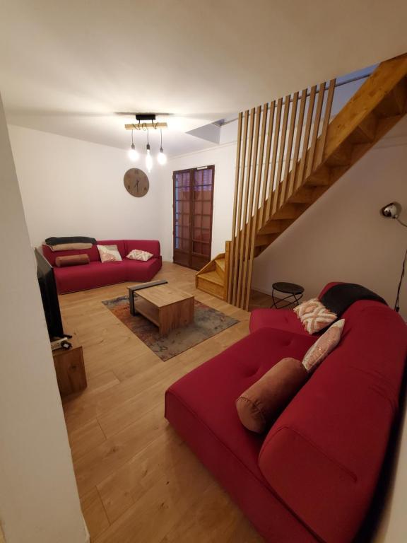 - un salon avec un canapé rouge et un escalier dans l'établissement Appartement 130 m2 Gourette, à Eaux-Bonnes