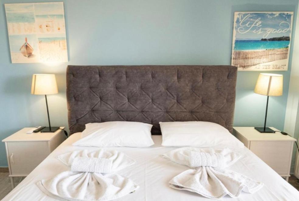 a bedroom with a bed with two white towels on it at Kanali seaside apartment Poros 1 in Poros