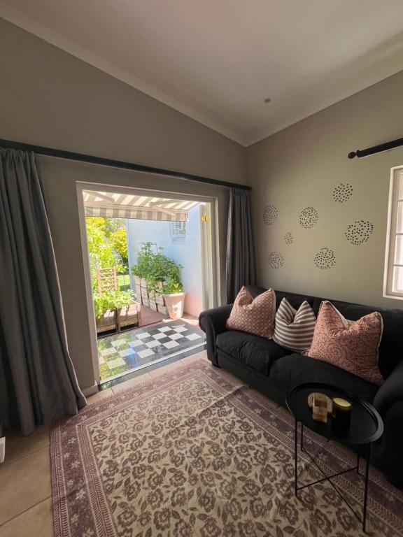 a living room with a couch and a large window at Bloom and Berry Cottage in Hallack Rock