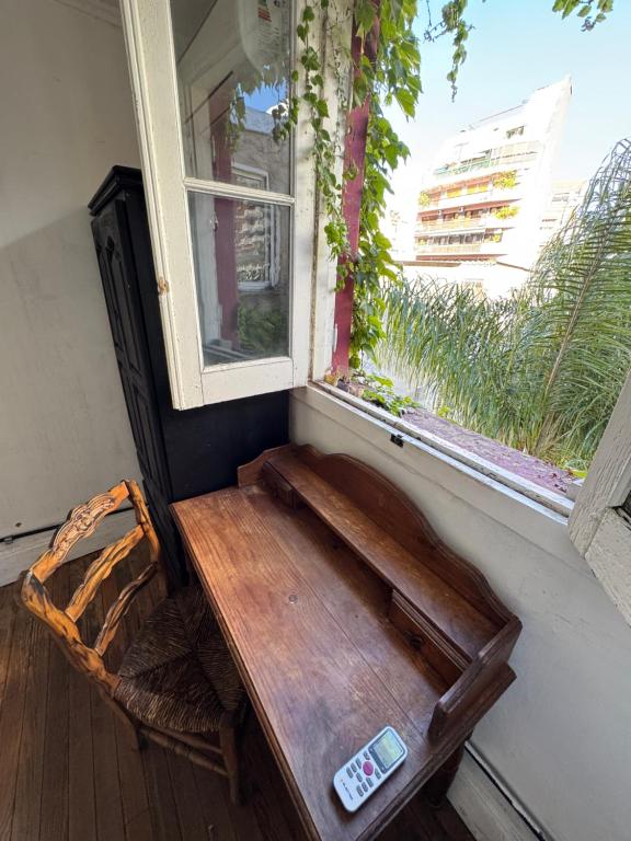 a wooden bench sitting in front of a window at Casamor in Buenos Aires