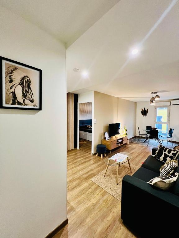 un salon avec un canapé noir et une table dans l'établissement T2 Beaux Arts parking privé gratuit, à Montpellier