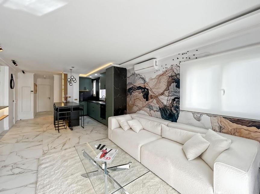 un salon avec un canapé blanc et un tableau mural dans l'établissement Appartement Moderne à Cannes, à Cannes