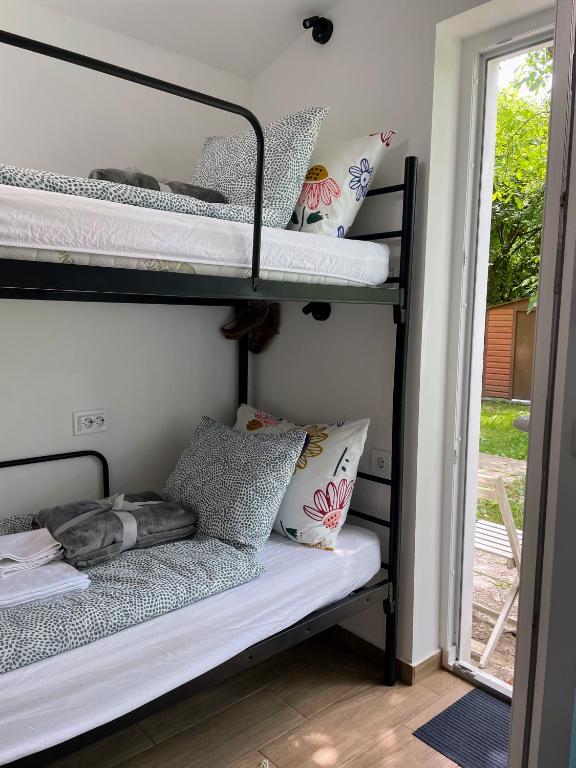 a room with a bunk bed with pillows and a window at Cozy little hideaway in Balatonfüred