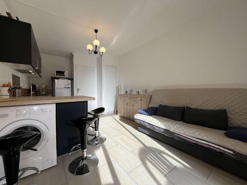 un salon avec un canapé et une machine à laver dans l'établissement Studio cabine avec piscine, 4 couchages, Gruissan - FR-1-229-60, à Gruissan