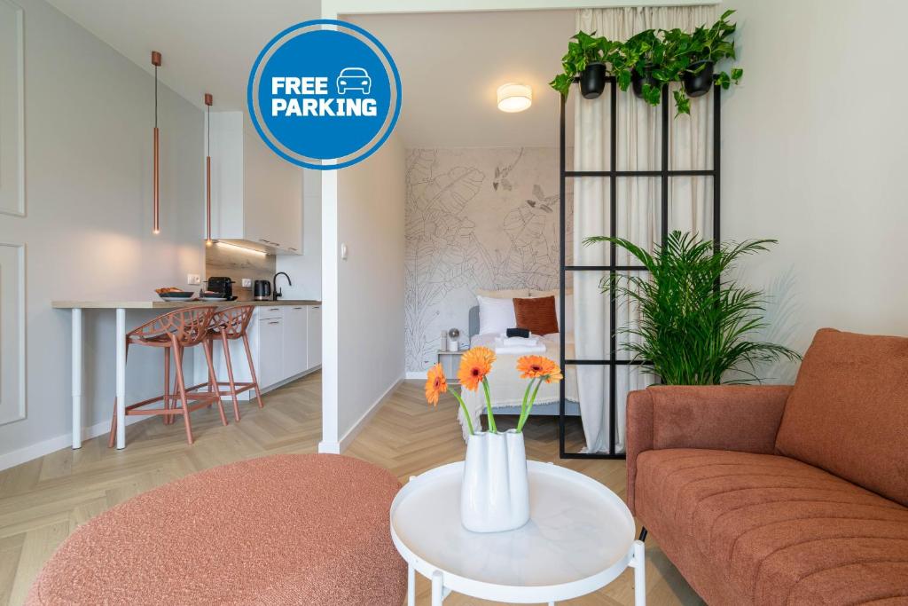 a living room with a couch and a vase with flowers on a table at Good Mood Francuska Retreat - FREE PARKING - Self check-in in Katowice