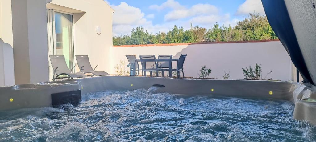 une baignoire jacuzzi dans l'arrière-cour d'une maison dans l'établissement Maison 2 chambres - proche de tout - Jacuzzi privatif, à Les Sables-dʼOlonne