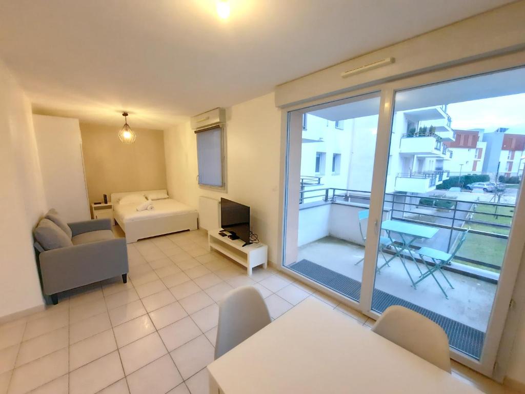 a living room with a view of a balcony at L'Apollinaire - 34m2 avec balcon et parking privé in Saint-Apollinaire