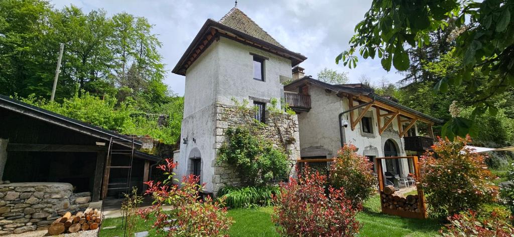 an old stone house in the middle of a yard at Domaine des moulins - La tour et son spa in Villy-le-Bouveret