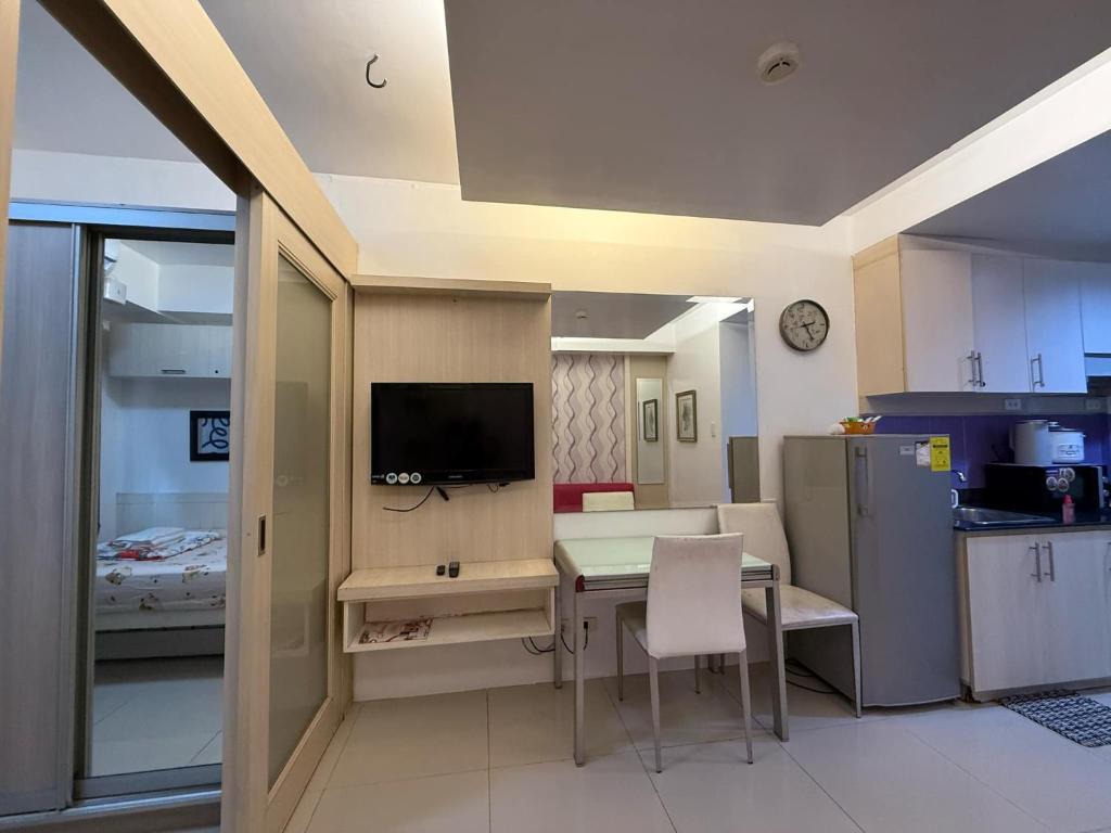 マニラにあるSea Residences MOA Pasay Manila - Rose Staycationのキッチン(テーブル付)、テレビが備わります。