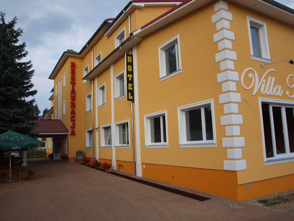 a yellow building with a sign on the side of it at Hotel Villa Nova in Żagań