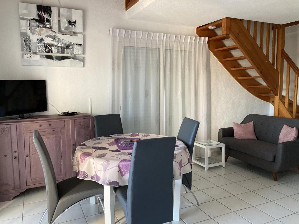 un salon avec une table et des chaises de salle à manger dans l'établissement les maisons bleues, à Capbreton