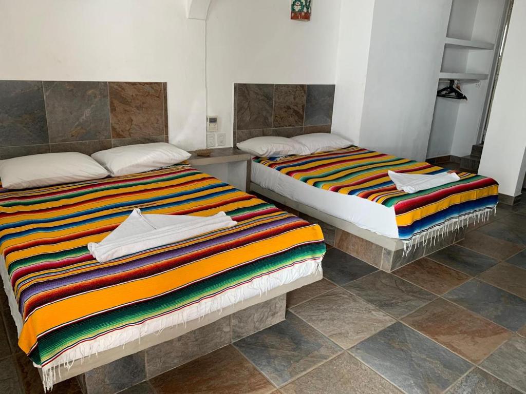 Postel nebo postele na pokoji v ubytování hotel las olas zicatela