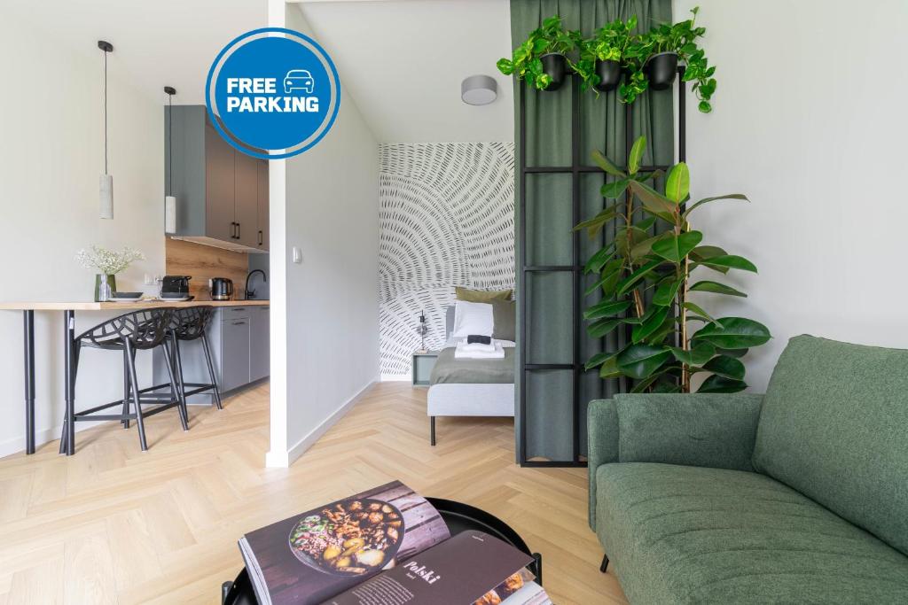 a living room with a green couch and a kitchen at Verde Kato Apartment Francuska - FREE PARKING - Self check-in in Katowice