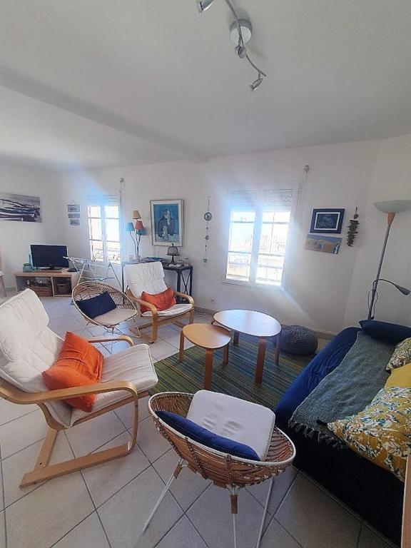 un salon avec des chaises et un canapé dans l'établissement agreable appartement situe en front de mer, à Soulac-sur-Mer