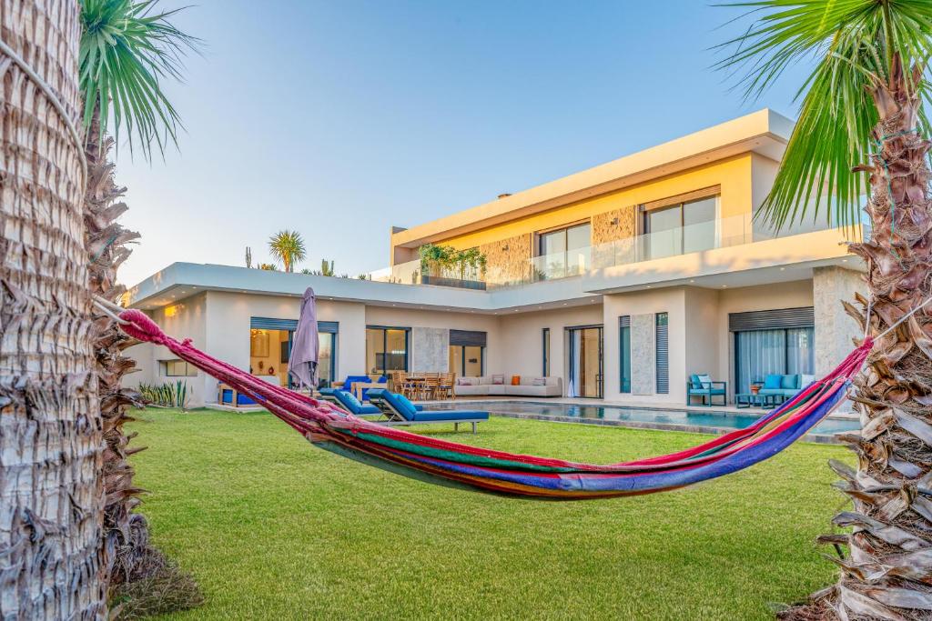 a hammock in front of a house at Villa Elysée - Piscine et jardin Privée Sans vis-à-vis Wifi HD in Sraghna