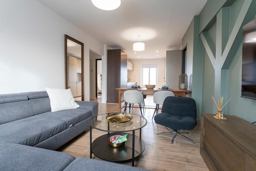 ein Wohnzimmer mit Sofa und Tisch in der Unterkunft Appartement historique Dior in Granville