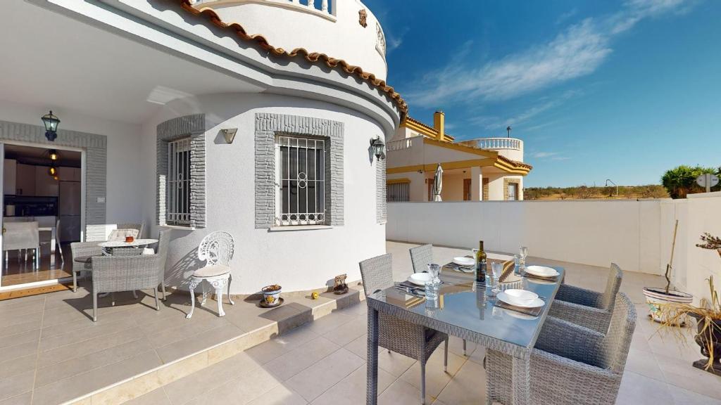 un patio avec une table à manger et des chaises sur une maison dans l'établissement Villa Pinos - A Murcia Holiday Rentals Property, à Sucina