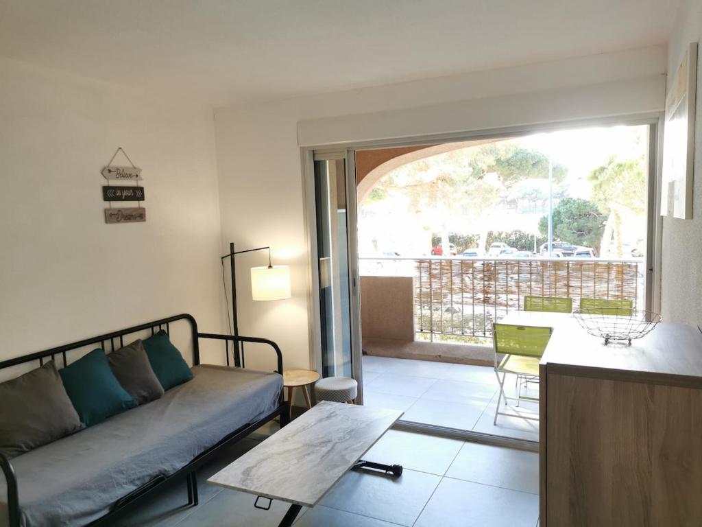un salon avec un canapé et une table dans l'établissement Appartement rénové Port de Hyères plage à pieds, à Hyères