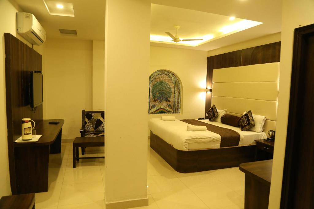 una habitación de hotel con dos camas y un escritorio en Hotel Krishna Palace, en Udaipur