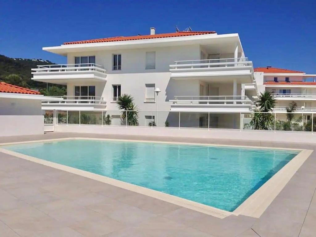 une villa avec piscine devant un immeuble dans l'établissement Le Royal Rivage - Piscine - À 200m de la mer, à Carqueiranne