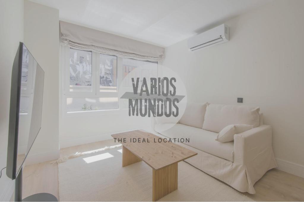 uma sala de estar com um sofá branco e uma mesa em Malasaña exclusiva para 4, ven a San Bernardo 20 E3 em Madrid