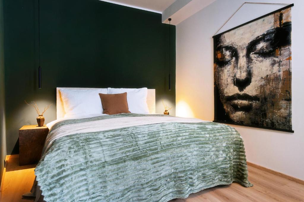 a bedroom with a green accent wall and a bed at Waterfront Riverside Premium Suites by ORY Living in Hamburg
