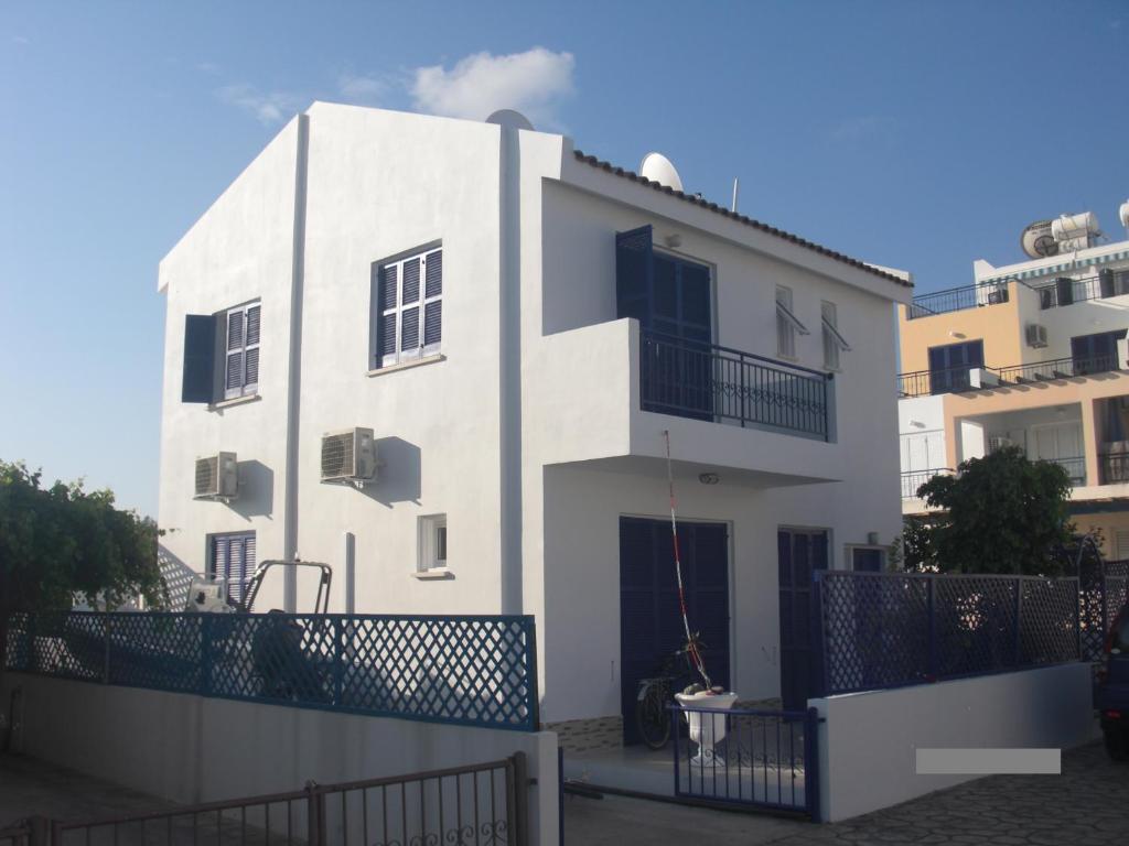 un condominio bianco con una recinzione di fronte di Villa Lachi a Polis Chrysochous