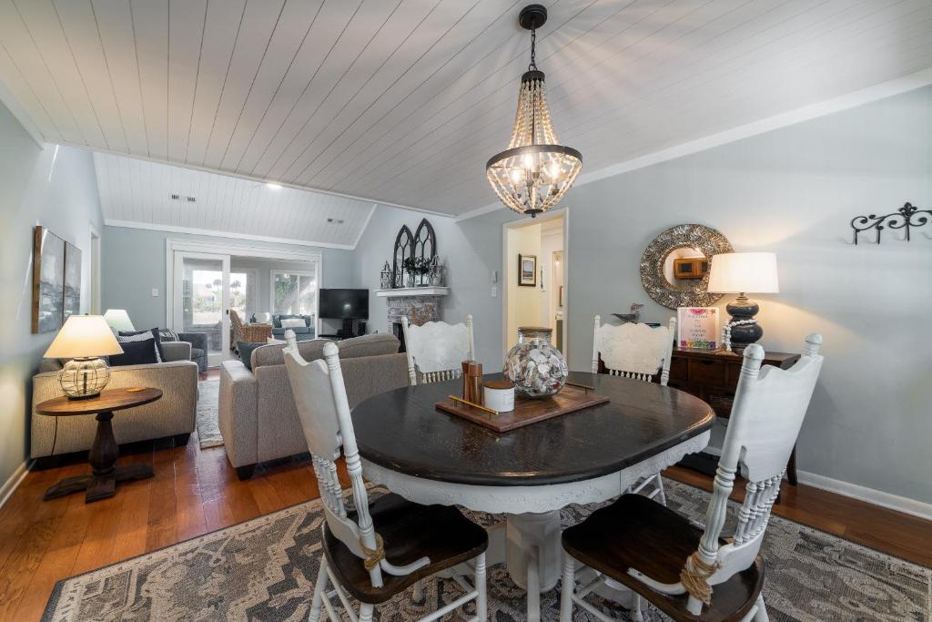 a dining room with a table and a living room at 546 Tarpon Pond Cottage in Seabrook Island