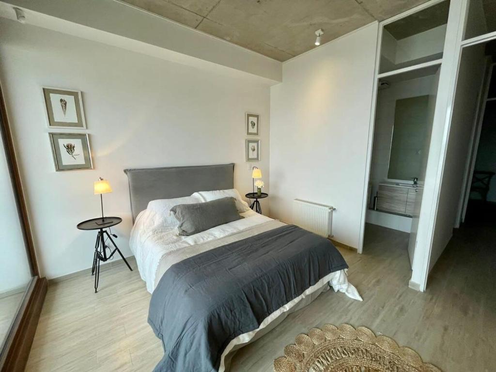 Un dormitorio con una cama y dos mesas y dos lámparas. en HOM I Duplex en Mejor Vista de Valparaiso y Parking, en Valparaíso