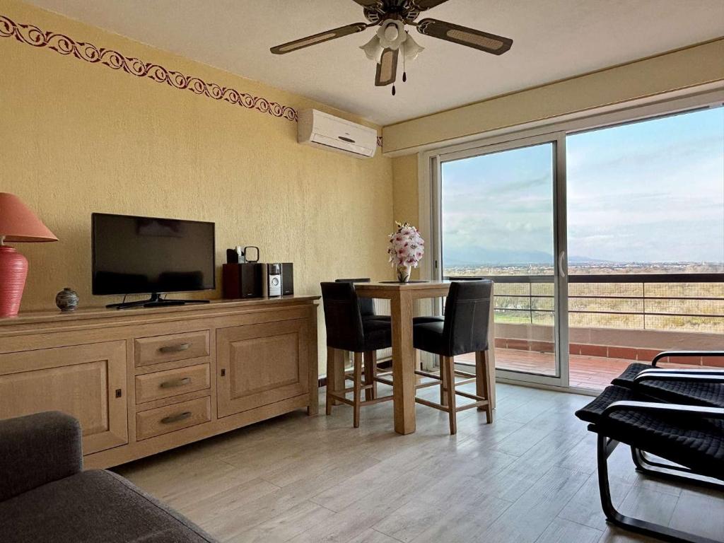 un salon avec une télévision et une table avec des chaises dans l'établissement Appartement 2 pièces cabine 6 couchages ARGELES SUR MER AR200-098, à Argelès-sur-Mer