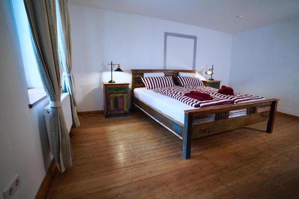 a bedroom with a bed and a wooden floor at RefuKium alte Brennerei - Im Zentrum von Weißenburg in Weißenburg in Bayern