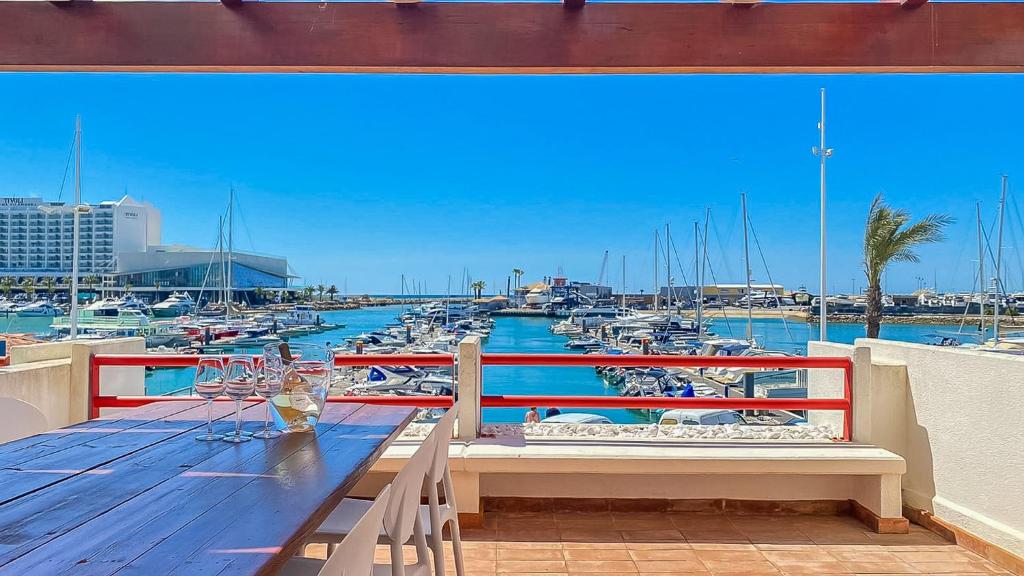 a balcony with a table and a marina with boats at Que sonho! Vista Marina T2 HsR Vilamarina in Vilamoura