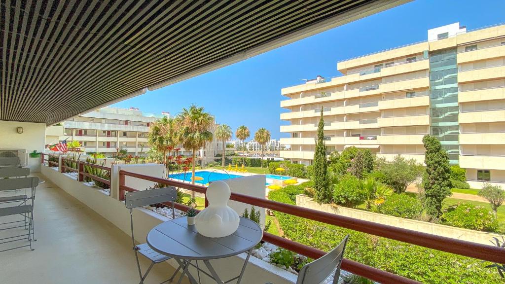 a balcony with a table and a view of a pool at YES! Incrível Vista Piscina T2 HsR Vilamarina in Vilamoura