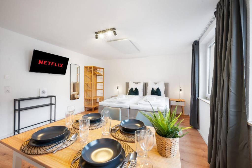 a dining room with a table and a bed at LudwigsCozyEscape - Ruhiges Design-Apartment mit Balkon & Parkplatz, 4 Gäste, SmartTV in jedem Zimmer, Highspeed WLAN, Workspace, 24h Self Check-in in Ludwigsburg