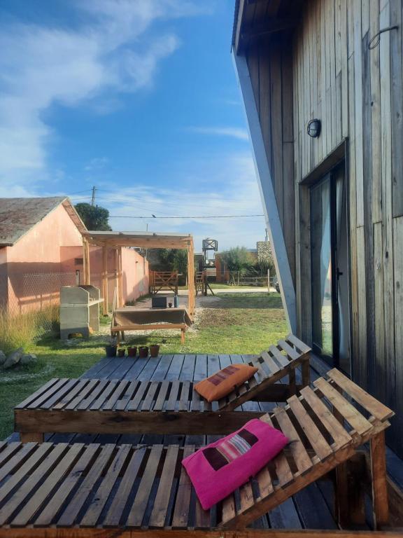 a wooden deck with a bench next to a building at AMARRA Camet Norte in Camet Norte