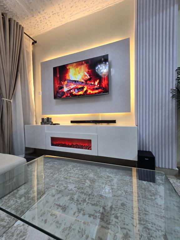 a living room with a tv on a wall at Silvia Homes Nanyuki in Nanyuki