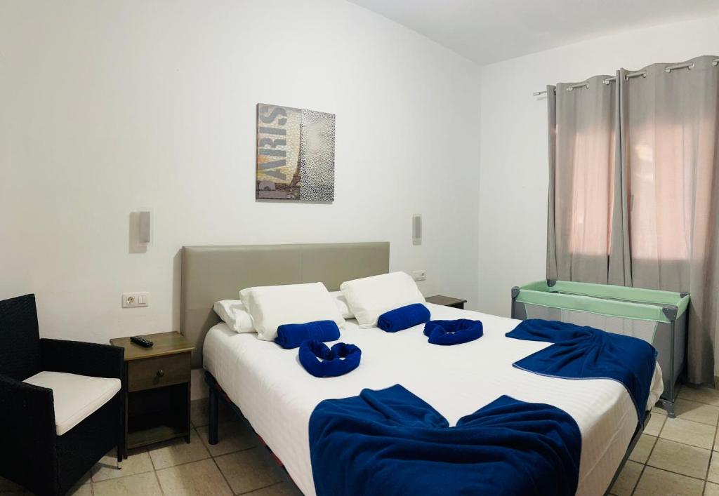 sypialnia z dużym łóżkiem z niebieskimi poduszkami w obiekcie Villa Nepal w mieście Playa Blanca
