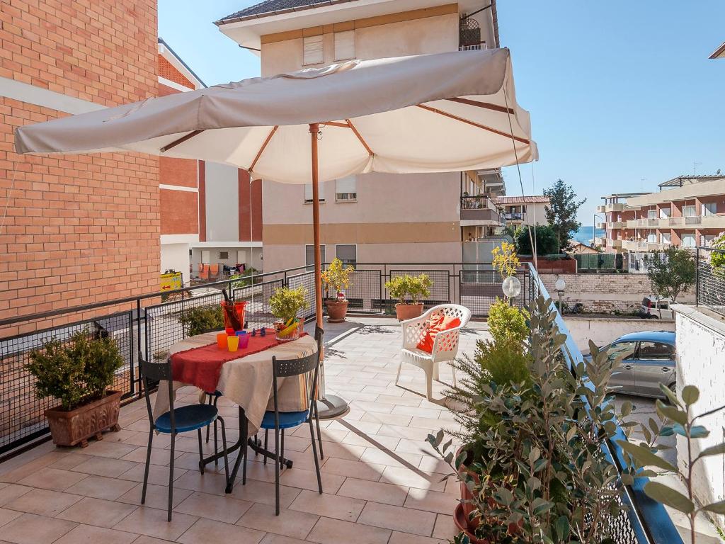 eine Terrasse mit einem Tisch und einem Sonnenschirm in der Unterkunft Casa Zirocco in Sperlonga