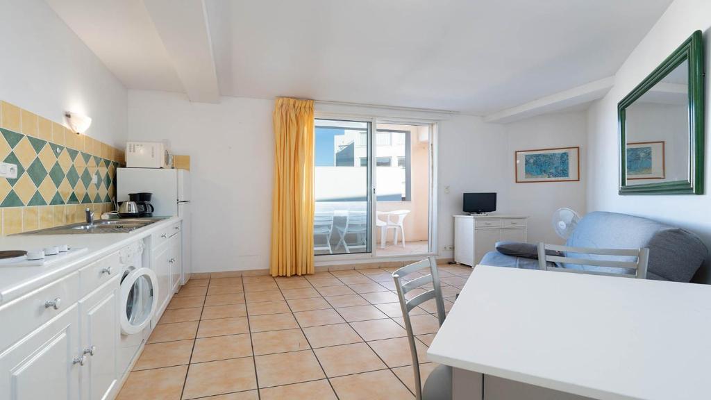 La cuisine est équipée d'un évier, d'un réfrigérateur et d'une table. dans l'établissement La Lamparo n202 - 2P4, au Cap d'Agde