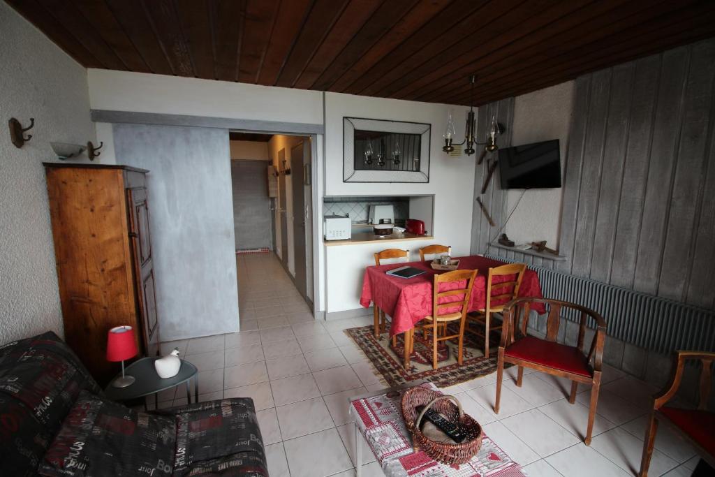 un salon avec une table et une cuisine dans l'établissement Praloup 1600 joli studio vue panoramique, à Pra-Loup