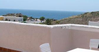 Un mur blanc avec deux chaises blanches et l'océan dans l'établissement Isleta del Moro TERRAZA VISTAS MAR Exclusiva 60 m2 WIFI, à La Isleta del Moro