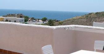 a white wall with two white chairs and the ocean at Isleta del Moro TERRAZA VISTAS MAR Exclusiva 60 m2 WIFI in La Isleta del Moro